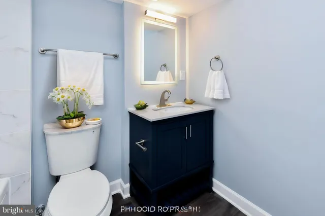 a bathroom with a granite countertop toilet sink and mirror
