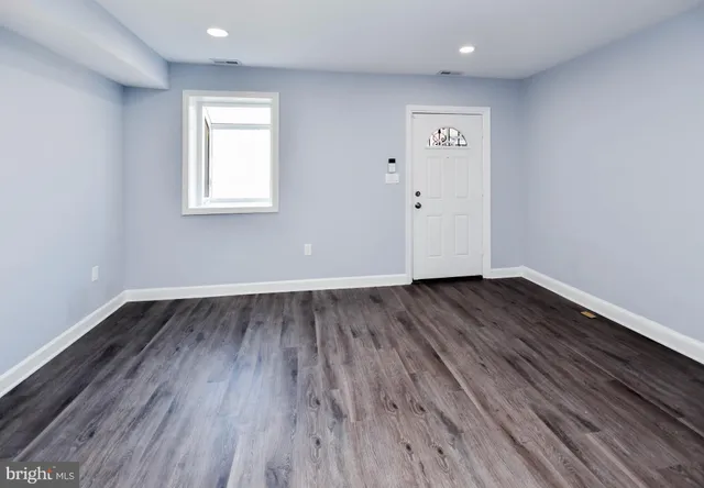 a view of a room with wooden floors and window