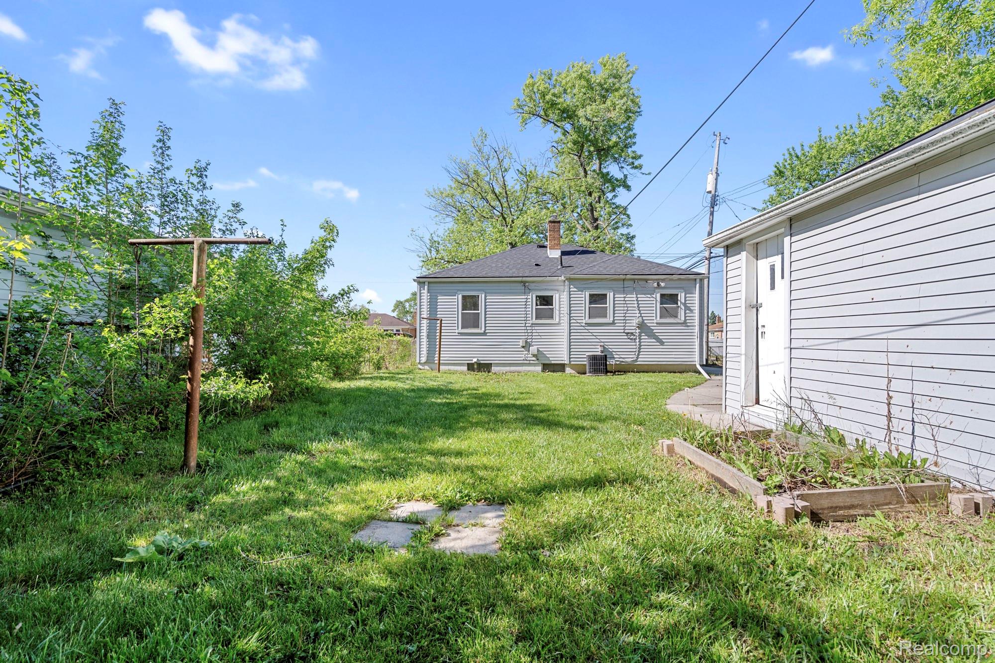 970 Champaign Road Lincoln Park, MI 48146 - Photo 27 of 28 Back of property with a garden, a yard, and a chimney