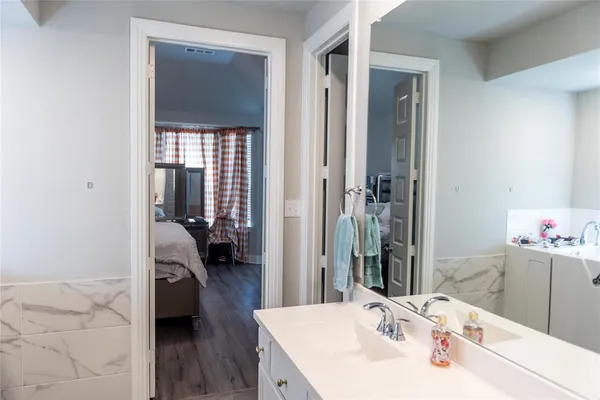 a en suite bathroom with a sink and a large mirror