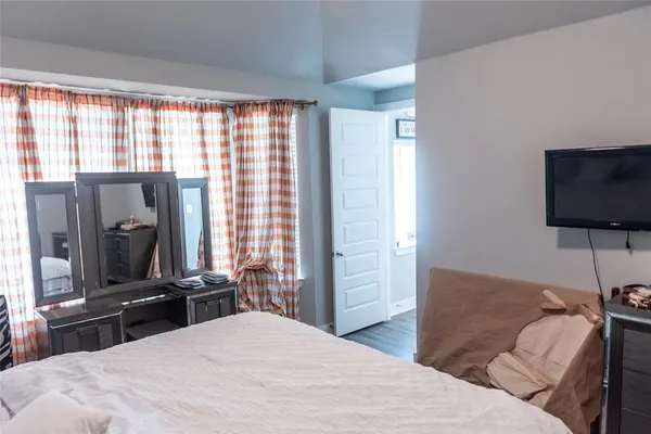 a bedroom with a bed and a flat screen tv