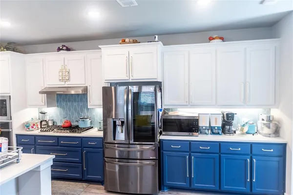 a kitchen with granite countertop a refrigerator and wooden cabinets