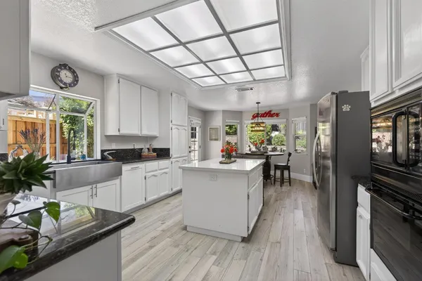 a kitchen with granite countertop lots of counter top space and wooden floor
