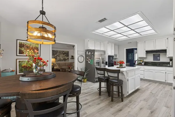 a kitchen with stainless steel appliances granite countertop a dining table chairs and granite counter tops