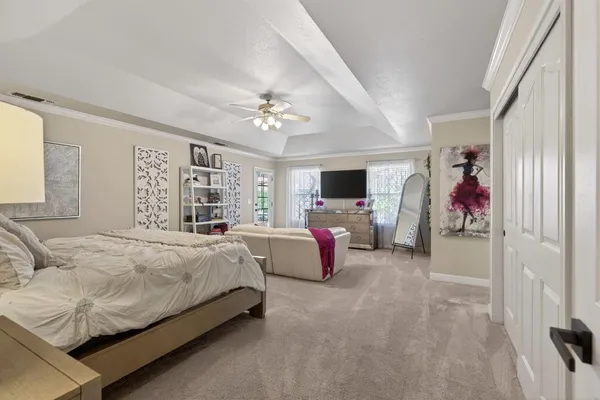 a spacious bedroom with a bed and a chandelier