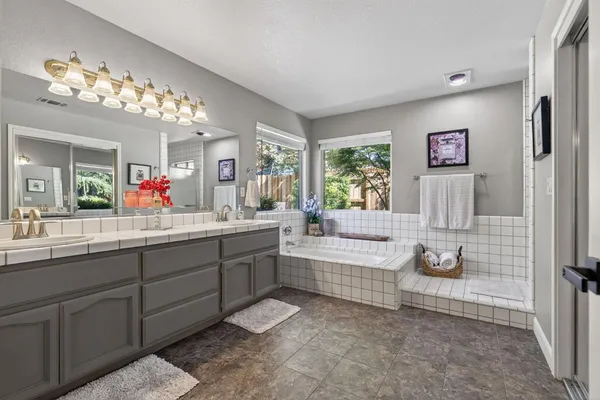 a bathroom with a tub sink and mirror