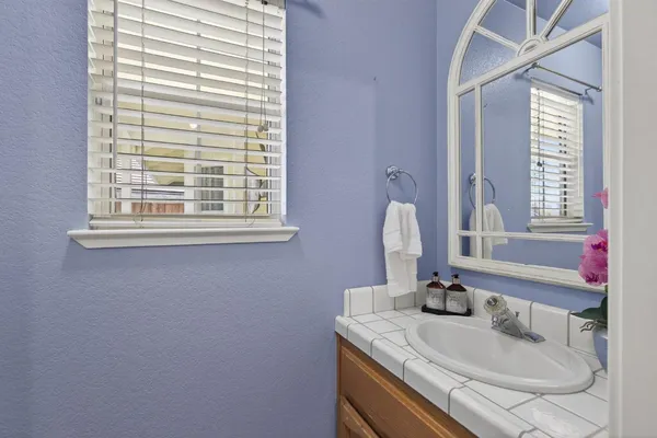 a bathroom with a granite countertop sink a mirror and a window