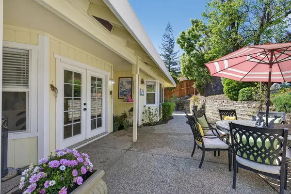 a view of a patio with a table and chairs under an umbrella