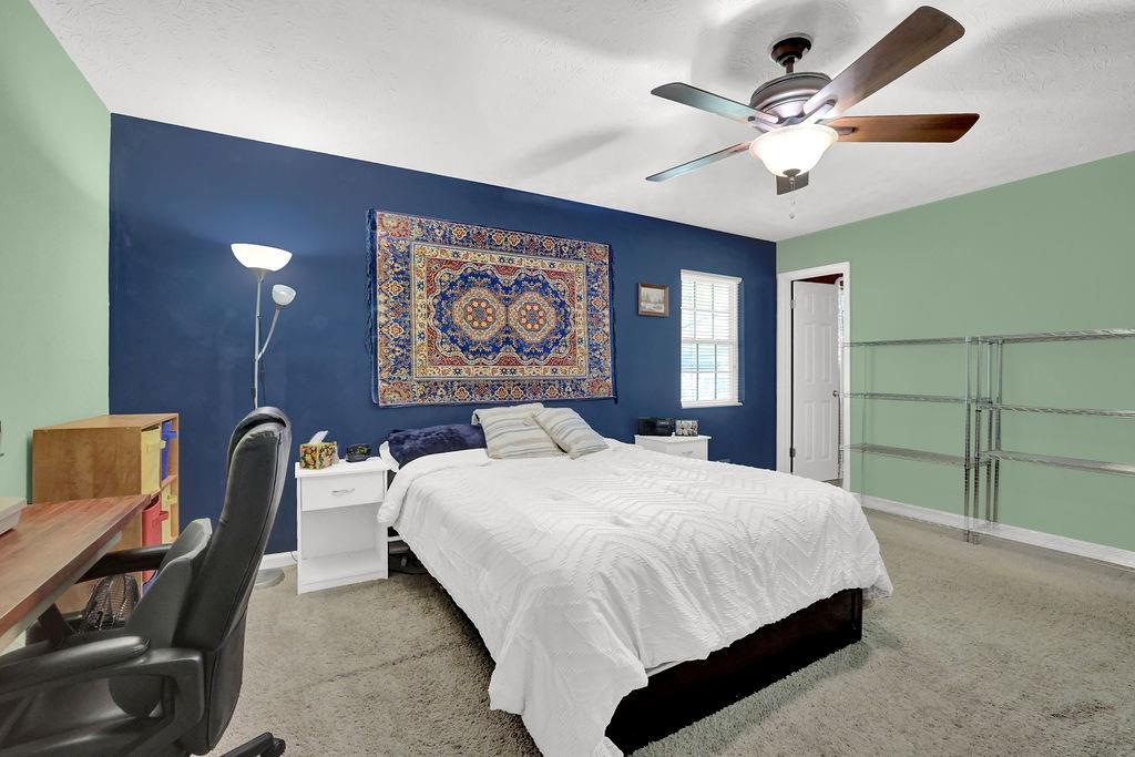 1555 Rock Springs Road Buford, GA 30519 - Photo 18 of 27 a bedroom with a bed and a chandelier