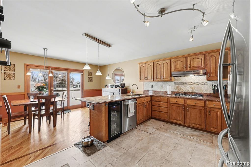 7277 Cardinal Road Algonac, MI 48001 - Photo 20 of 36 Kitchen featuring a peninsula, stainless steel appliances, wood finish cabinetry, and decorative light fixtures
