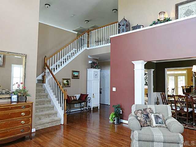 3212 Queensland Road Raleigh, NC 27614 - Photo 3 of 25 This living room offers 20 foot ceilings, large windows with plantation blinds, wood floors and a wonderful staircase.
