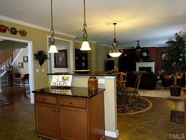 3212 Queensland Road Raleigh, NC 27614 - Photo 25 of 25 Another view from the kitchen into the family room. The separate bar allows conversation while preparing meals, or grabbing a quick snack. The open floor plan is great for entertaining or being close to the family.
