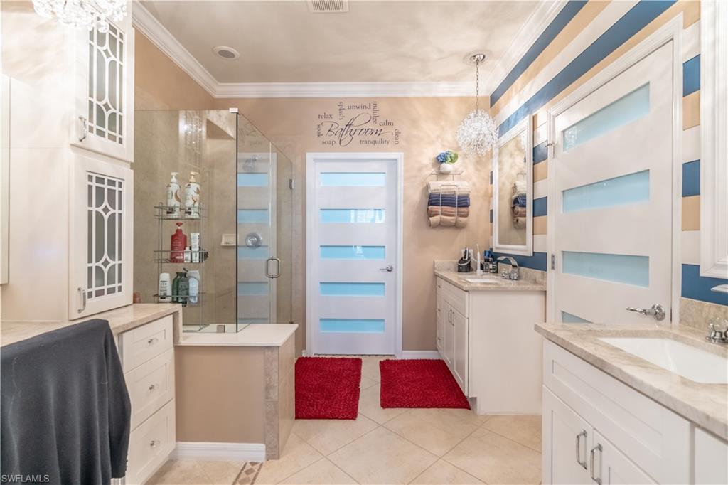 8883 Ravello Court Naples, FL 34114 - Photo 23 of 35 Bathroom with double vanity, tile patterned flooring, a shower with door, and ornamental molding