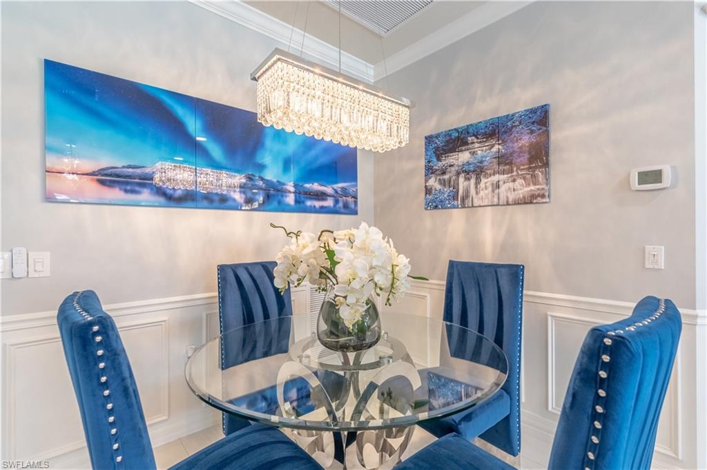 8883 Ravello Court Naples, FL 34114 - Photo 10 of 35 Dining space featuring crown molding and a notable chandelier