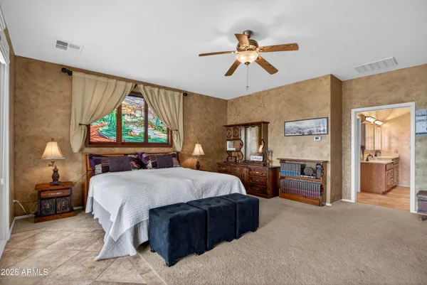 a spacious bedroom with a bed and a chandelier