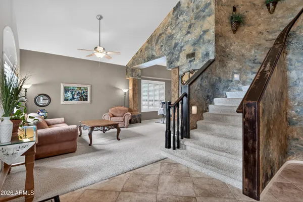 a living room with furniture a clock on wall and a window