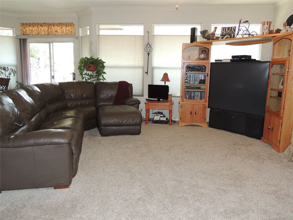 a living room with furniture a flat screen tv and large window