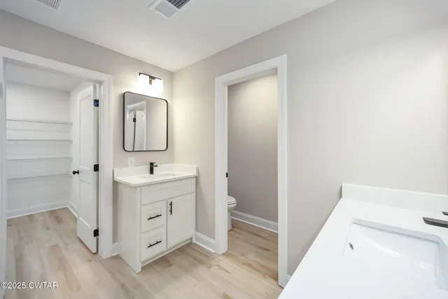 a view of bathroom with mirror and wooden floor