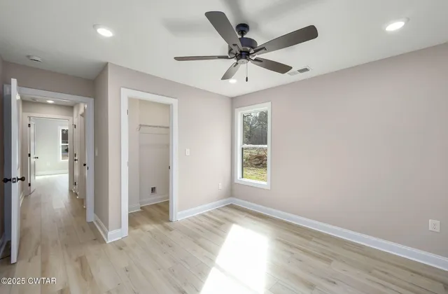 a view of a livingroom with a ceiling fan and window