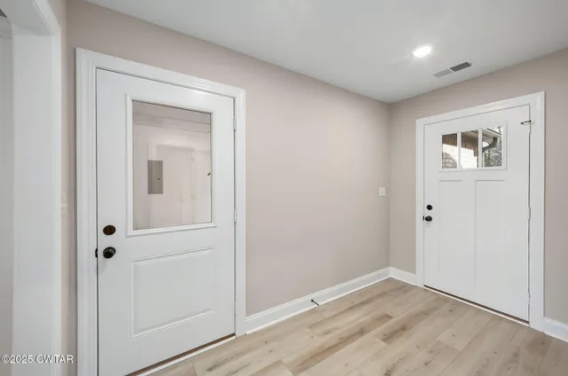 an empty room with wooden floor and closet