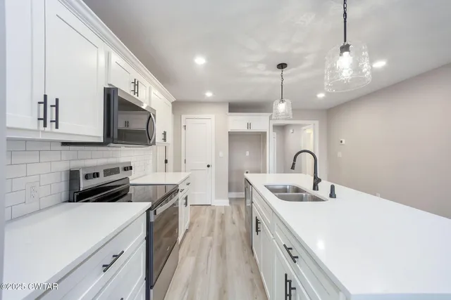 a kitchen with a sink a stove and cabinets