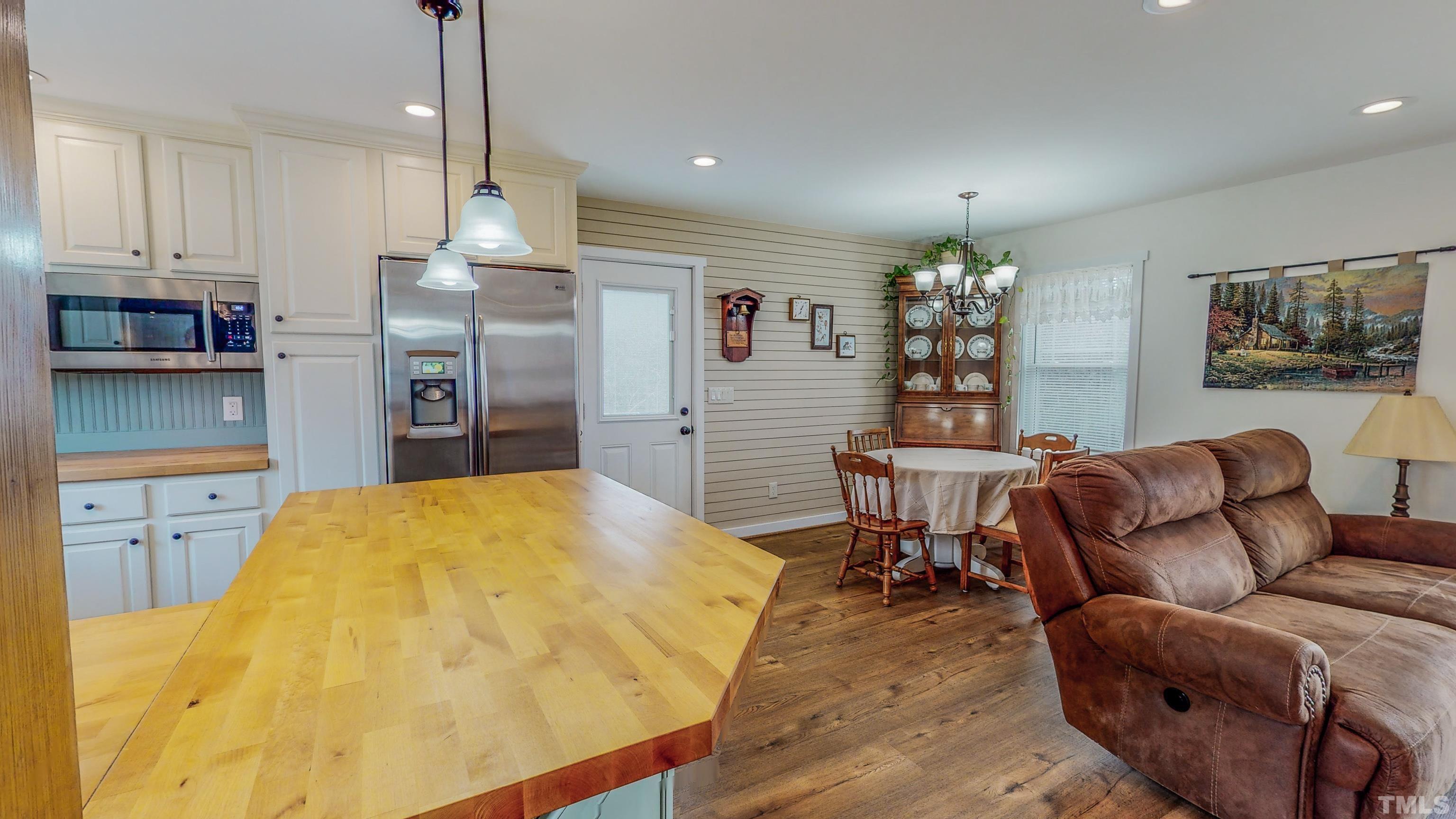 155 Alva Oakley Road Roxboro, NC 27574 - Photo 16 of 42 a living room with stainless steel appliances kitchen island granite countertop furniture and a wooden floor