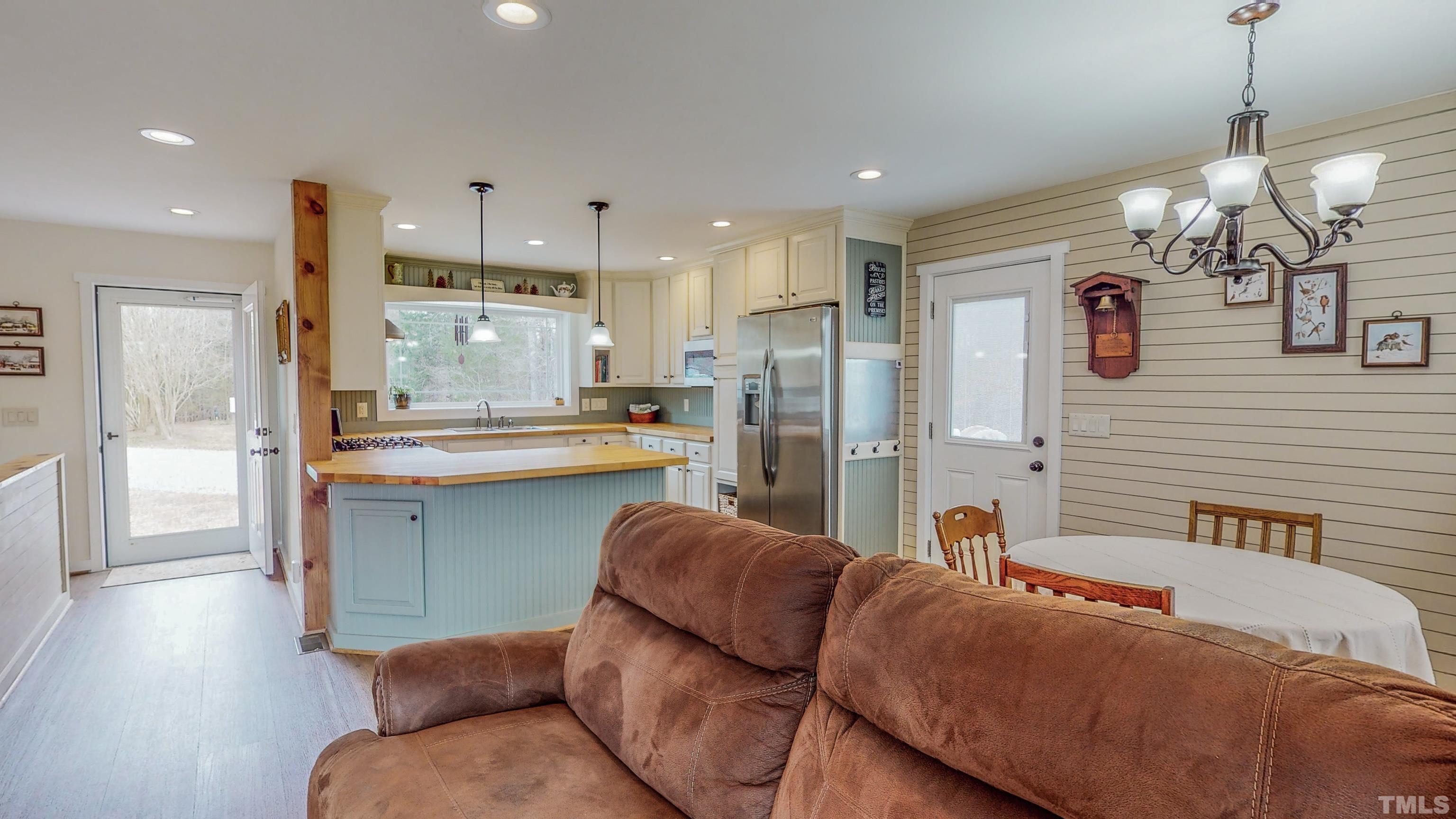 155 Alva Oakley Road Roxboro, NC 27574 - Photo 33 of 42 a living room with kitchen island furniture and a chandelier