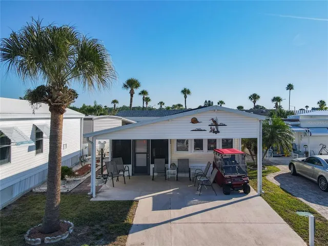 a view of a patio with table and chairs potted plants and palm tree