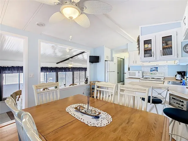 a kitchen with stainless steel appliances kitchen island granite countertop a dining table and chairs