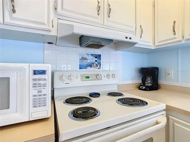 a white stove top oven sitting inside of a kitchen
