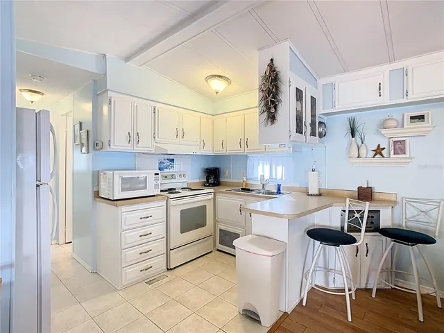 a kitchen with a stove cabinets and chairs