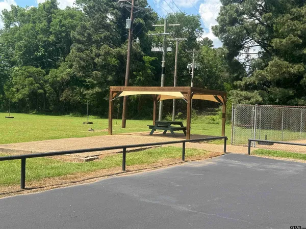 a view of a park with large trees and a slide