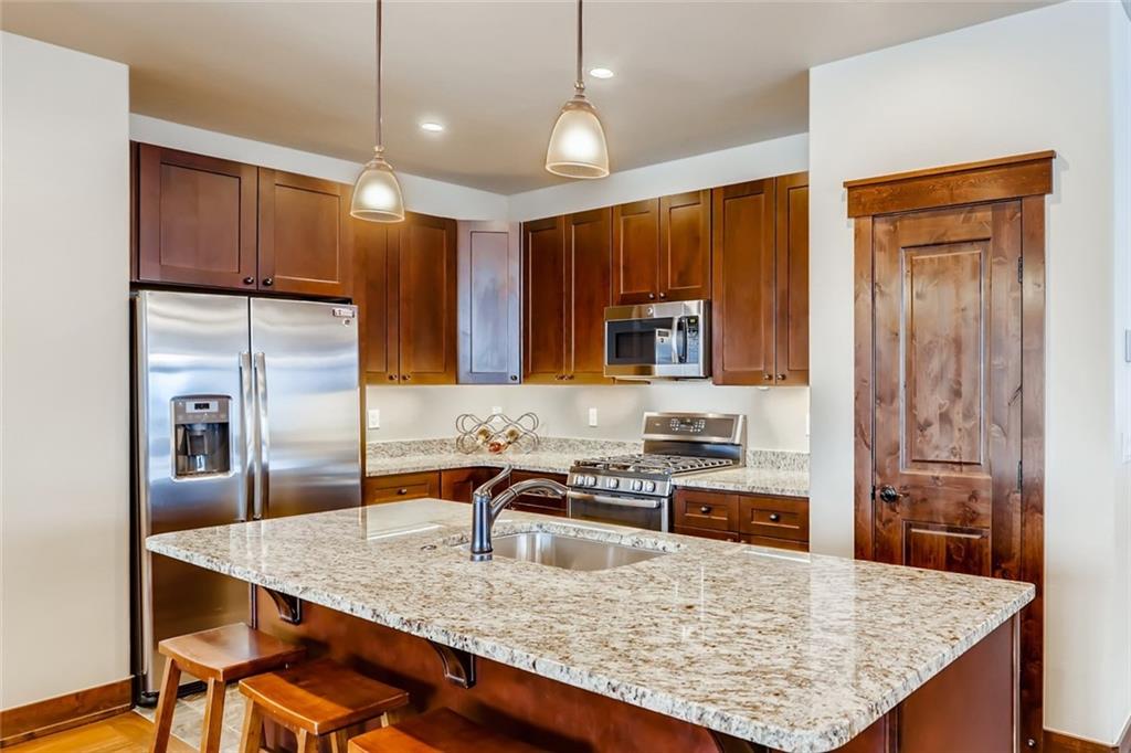 867 Independence Road, Unit 4A Keystone, CO 80435 - Photo 17 of 28 a kitchen with kitchen island granite countertop a sink stove and refrigerator