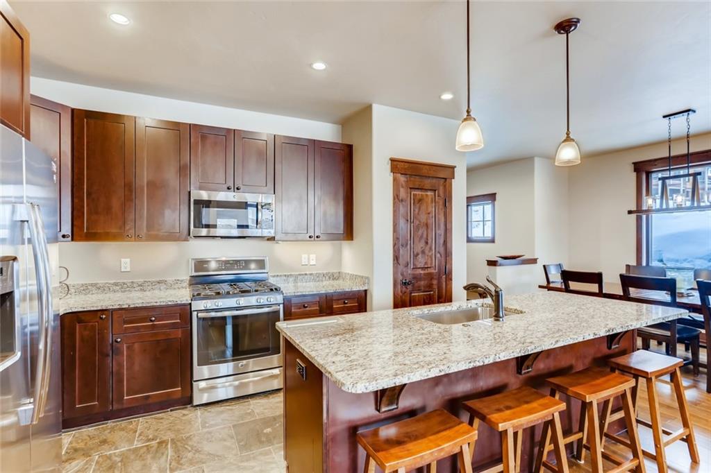 867 Independence Road, Unit 4A Keystone, CO 80435 - Photo 28 of 28 a kitchen with stainless steel appliances granite countertop a stove a sink dishwasher and a refrigerator with wooden floor