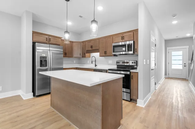 a kitchen with stainless steel appliances granite countertop a sink a stove and a refrigerator