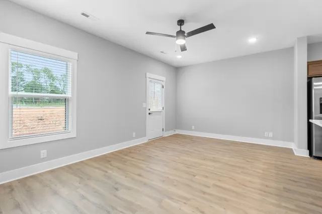 a large kitchen with stainless steel appliances a large counter top a stove and a refrigerator