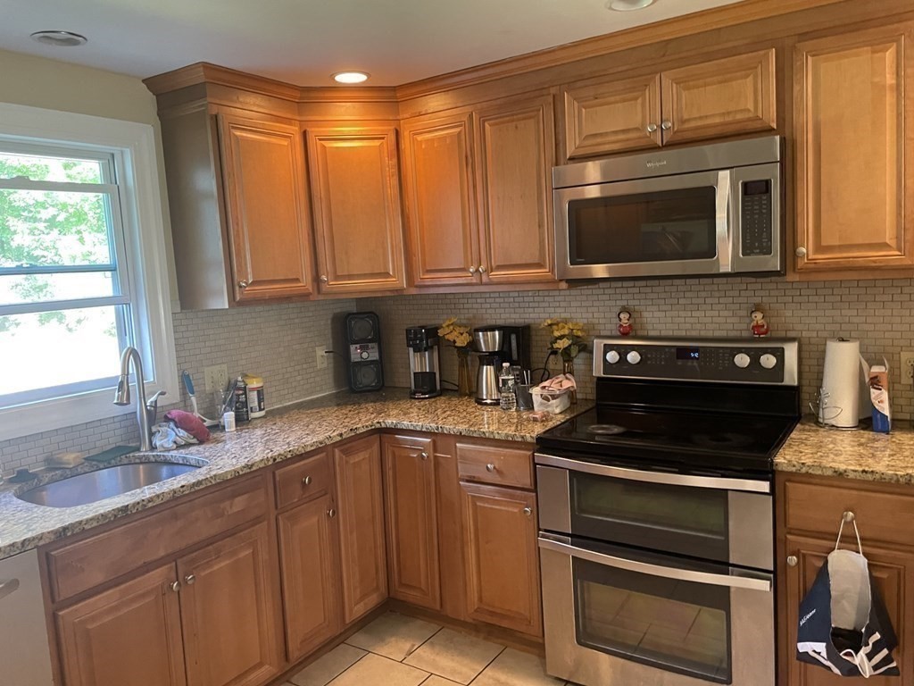 20 Johnson Street Ashland, MA 01721 - Photo 3 of 24 a kitchen with stainless steel appliances granite countertop a sink stove and microwave
