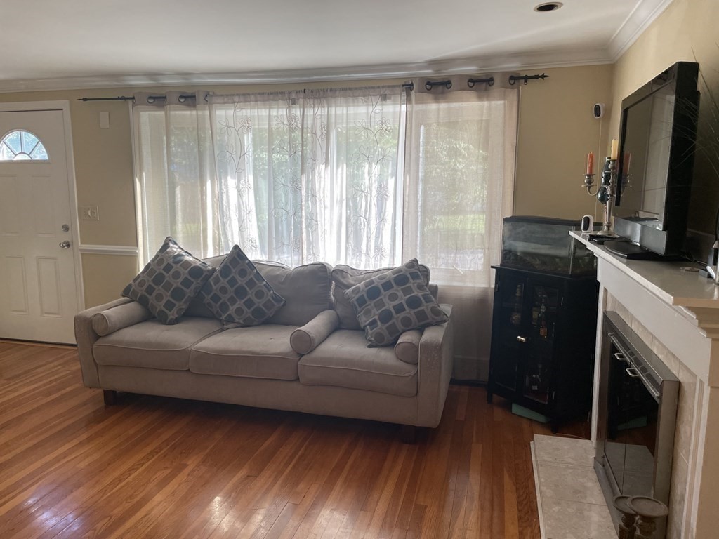 20 Johnson Street Ashland, MA 01721 - Photo 5 of 24 a living room with furniture a flat screen tv and a fireplace