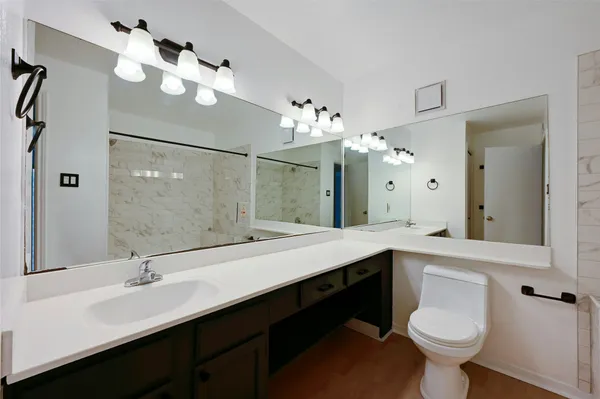 a bathroom with a double vanity sink mirror and toilet