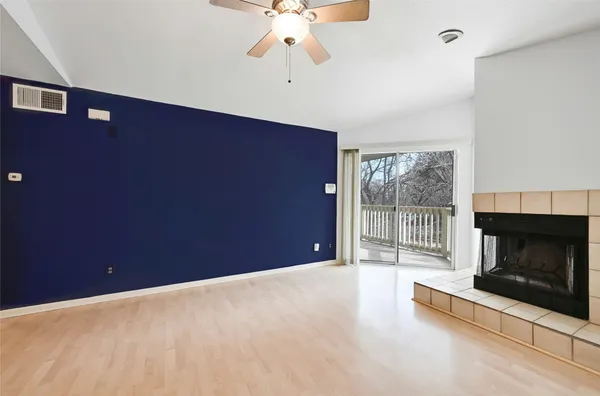 a view of an empty room with a fireplace and a window