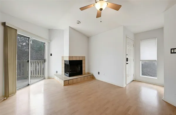 a view of an empty room with a fireplace and a window