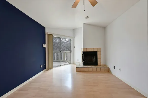 a view of an empty room with a window and fireplace