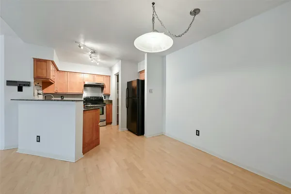 a kitchen with stainless steel appliances a refrigerator and a chandelier