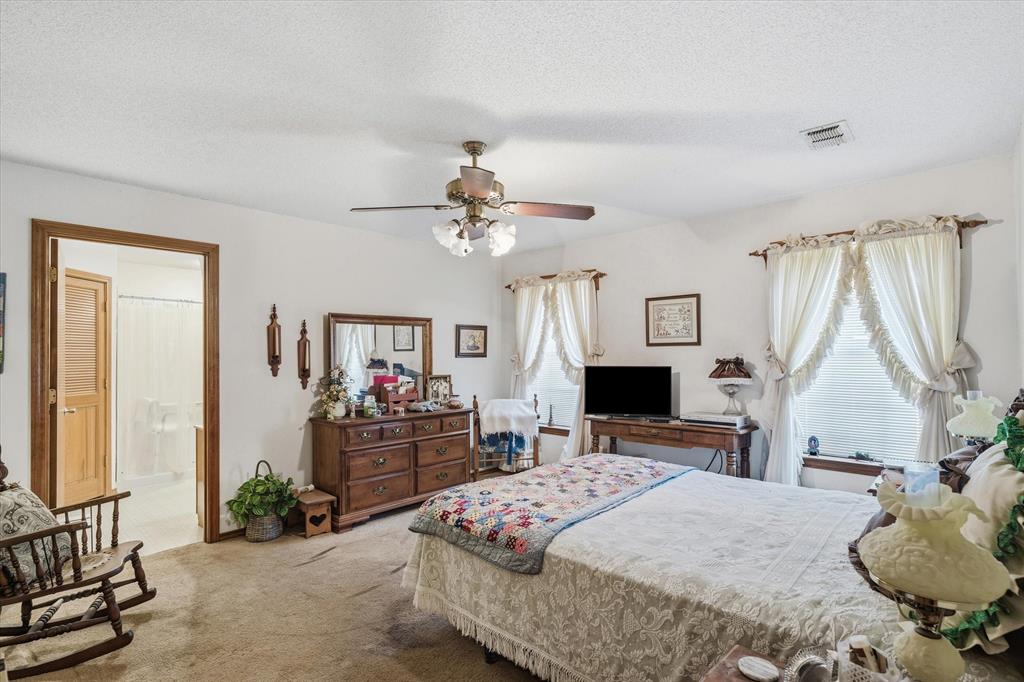 122 Bull Durham Road Wills Point, TX 75169 - Photo 12 of 33 a bedroom with a bed and a chandelier