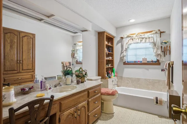 a bathroom with a granite countertop sink a toilet and bathtub
