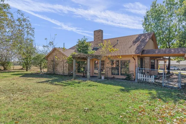 a view of a house with a yard and sitting area