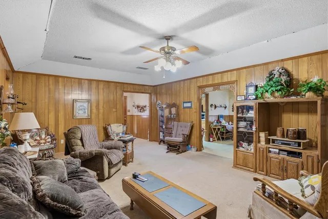 a living room with furniture a flat screen tv and a window
