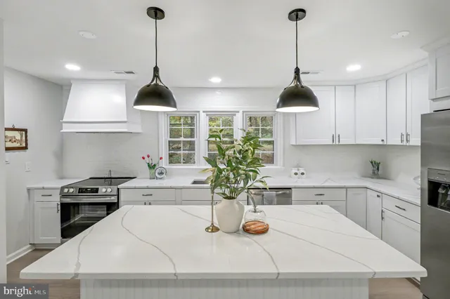 a kitchen with stainless steel appliances granite countertop a sink a stove and a wooden floors
