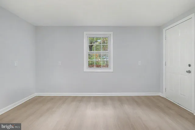 a view of a room that has wooden floor and window