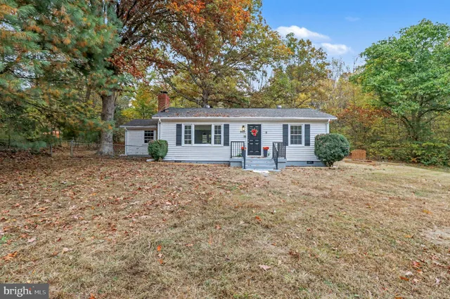 a front view of house with yard and trees around
